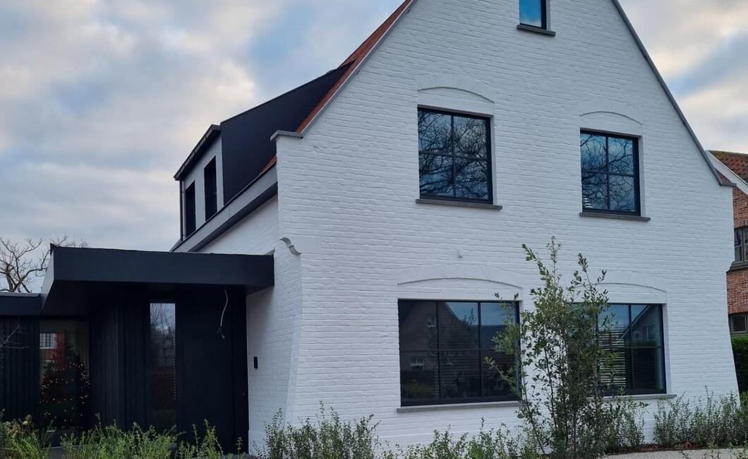 Zwarte slim line steellook ramen van reynaers in een wit geschilderde woning