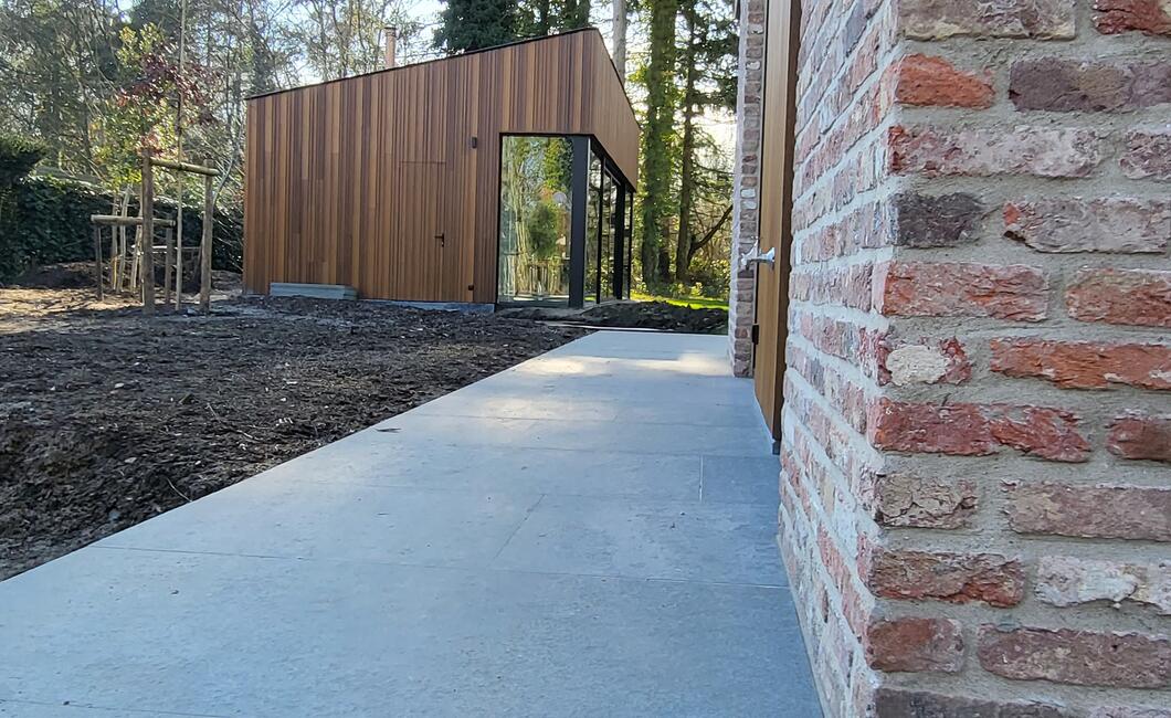 Zicht op het bijgebouw met houten gevelbekleding
