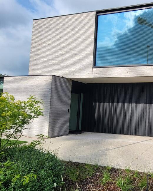 High-end villa met zwarte aluminium ramen en verticale gevelbekleding – moderne architectuur met strakke lijnen
